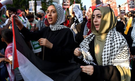 Women at the front of a march wearing keffiyehs.