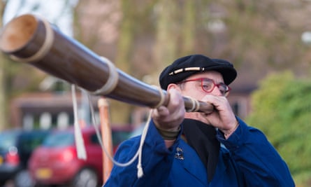Unknown man blowing a so called midwinterhorn, a traditional handmade wooden instument. It is used in the Netherlands.