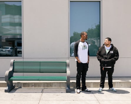 Two men guidelines adjacent to a greenish bench