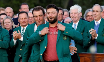 Jon Rahm is presented with a Green Jacket by Scottie Scheffler after winning the 2023 Masters