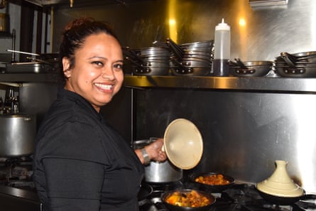 a women smiling in front of a stove
