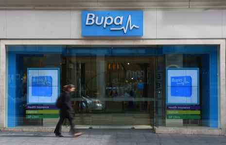 A woman walks past a Bupa Health Insurance branch in Sydney.