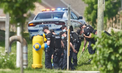 Police officers look for evidence at the scene of the crash in London, Ontario, on 7 June. 