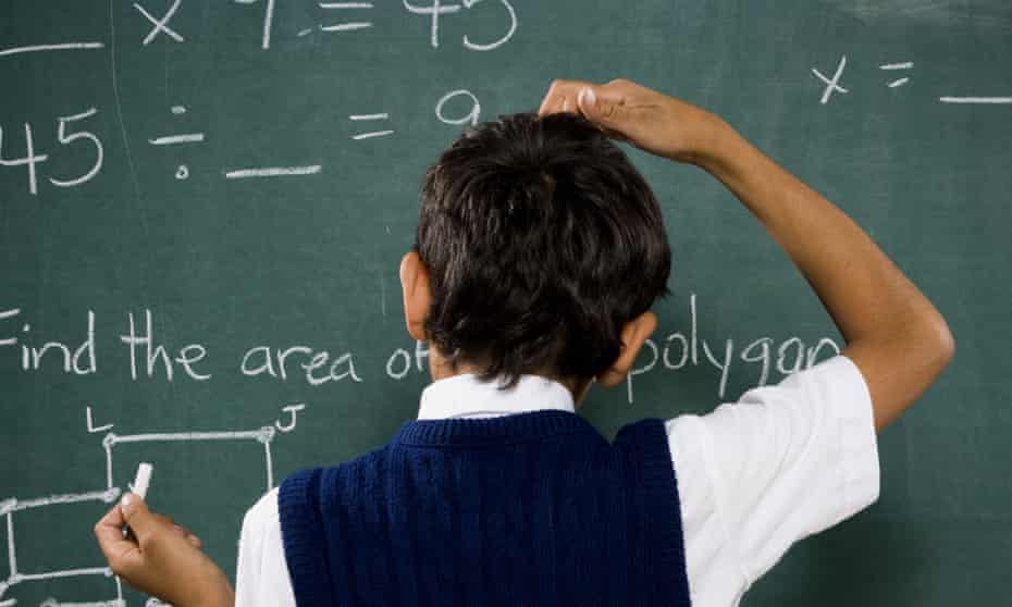 Boy at a chalkboard doing equations