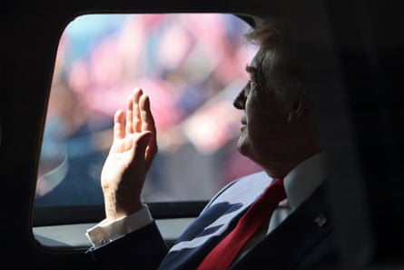 Donald Trump waves from his official vehicle known as he leaves Kuala Lumpur international airport on Sunday.