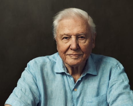 Head and shoulders shot of David Attenborough in blue shirt against dark background