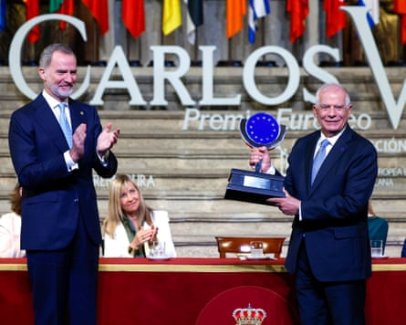 King Felipe applauds as Josep Borrell holds the Charles V European award at a public ceremony