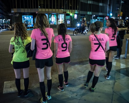 hen do women in pink football-style shirts and black shorts and socks pictured in Barcelona at night