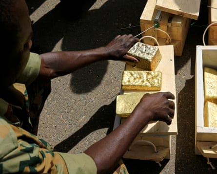 A person in military uniform handling gold bars