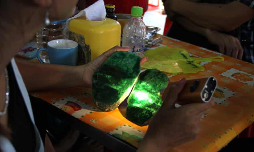 A woman examines the quality of a jade stone from the Hpakant mine area.