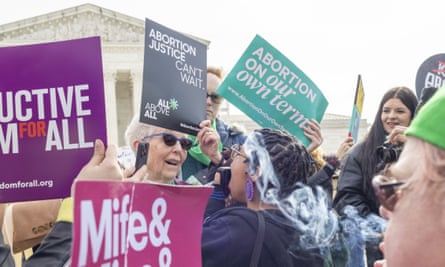 Older white woman face-to-face with younger Black woman, both speaking or yelling, holding opposting signs.