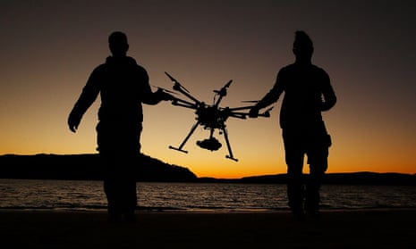 Two men carrying a commercial drone
