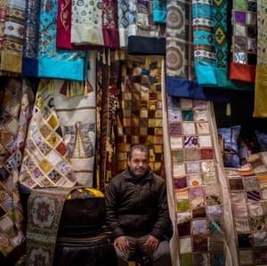 Yasin Kizilkaya with rugs and fabrics on sale