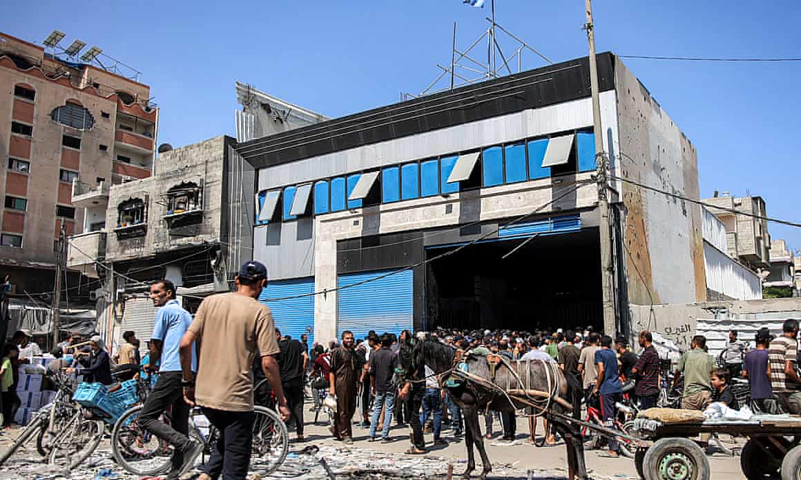A large crowd gathers in front of a warehouse in Gaza City
