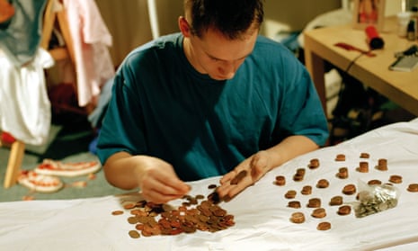 Yong man counting coins on a bed