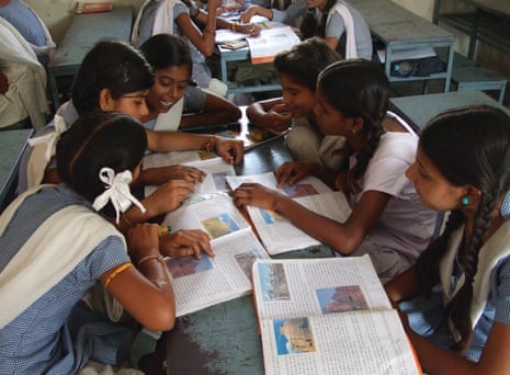A group of school children in a classroom in India discuss their work
