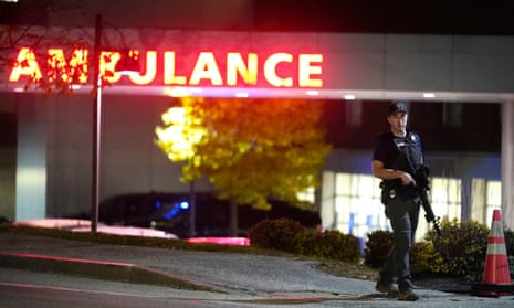 A law enforcement officer carries a rifle outside the Central Maine Medical Center.