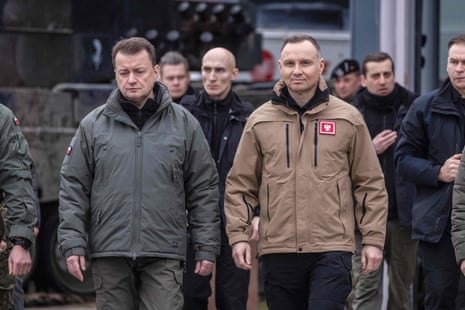 Polish defence minister Mariusz Błaszczak (L) and President Andrzej Duda arrive for a meeting with instructors who train Ukrainian soldiers on Leopard 2 tanks at the Świętoszów military base
