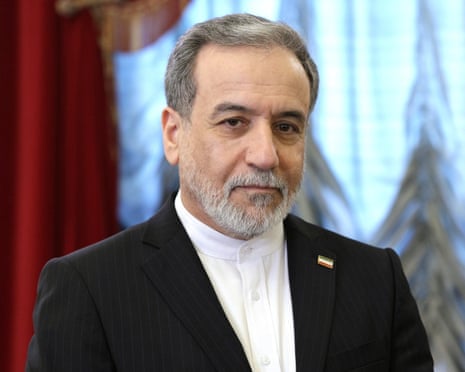 Araghchi in a dark pinstripe suit looks directly at the camera