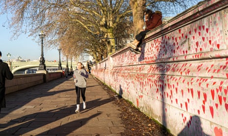 People are seen near the Covid national memorial wall on the Thames Embankment 