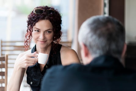 A woman and man in coffee shop. The woman is looking towards the man