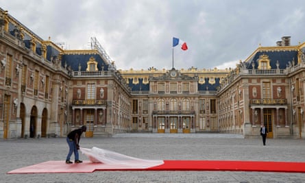 A worker unveiling the red carpet at the Palace of Versailles before the state banquet.