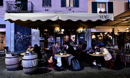 People sit outdoors at a cafe in Milan.