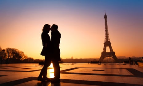 A couple kissing near the Eiffel Tower at sunset