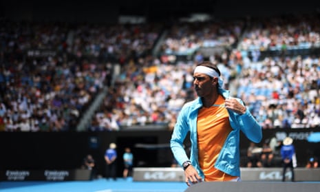 Nadal peels off his training top.