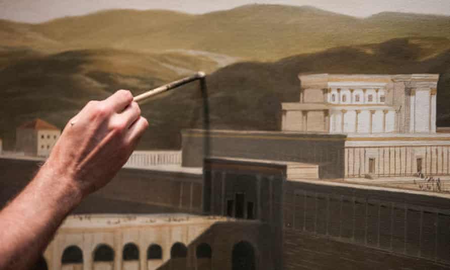 A painter works on a mural at the Museum of the Bible