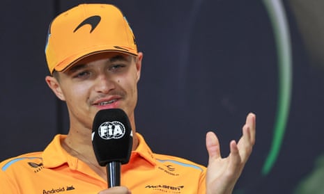 Lando Norris holds a microphone while speaking to media before the Emilia-Romagna Grand Prix.
