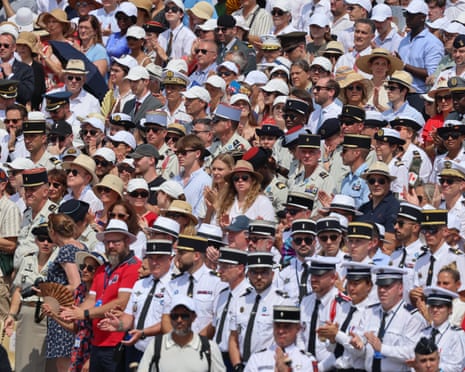Guests and troops applaud during the annual Bastille Day military parade on the Champs-Elysees Avenue in Paris.