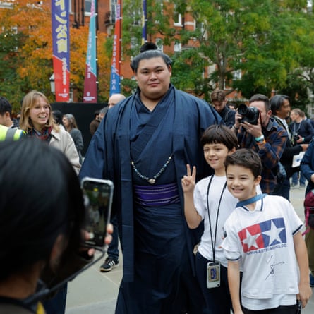 Onosato is stopped by fans for a photo as he walks to the Royal Albert Hall