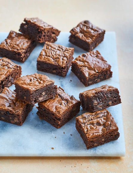 Squares of chocolate brownie on a light-blue marble tile.
