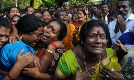 Supporters of Jayalalithaa Jayaram react outside the hospital to the first report of her death.