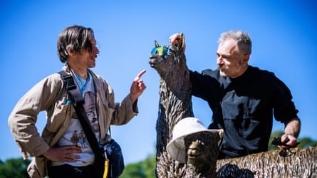 Artist Jeremy Deller (left) and conductor Charles Hazlewood sitting on a llama statue.