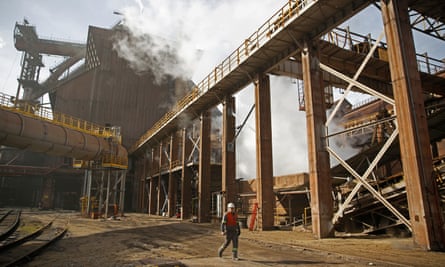 A worker walks in front of ArcelorMittal steel factory.