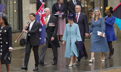 Sam Kerr holds the Australian flag as she leads the Australian delegates including prime minister Anthony Albanese, arriving at Westminster Abbey.