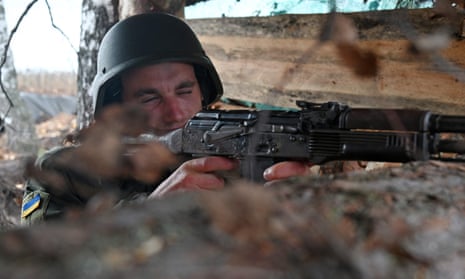 A Ukrainian solider takes position in a trench in the northern occupied territories of Kharkiv region