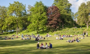 People enjoying a sunny evening in Kelvingrove Park, Glasgow.