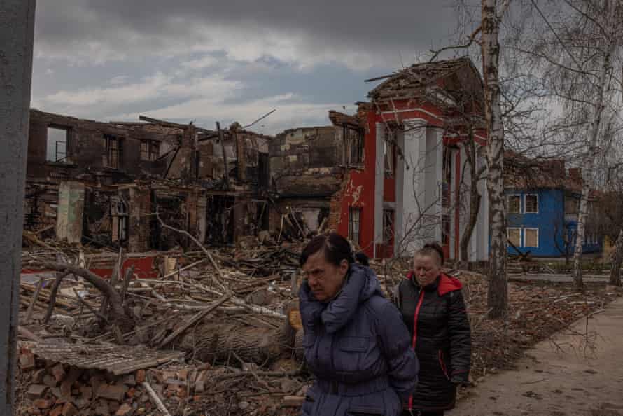 People walk past the destroyed lyceum of food technologies and trade in Kharkiv, northeast Ukraine.