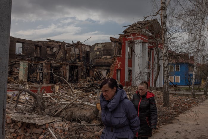 People walk past the destroyed lyceum of food technologies and trade in Kharkiv.