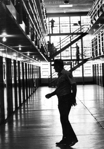 A guard crosses an open area in an old maximum security prison.