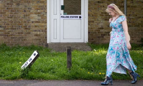 A woman walks past a polling station in Egham in Surrey.