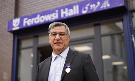 Dr Nooralhaq Nasimi, the founder of the Afghan and Central Asian Association (ACAA), standing outside a sign reading Ferdowsi Hall.