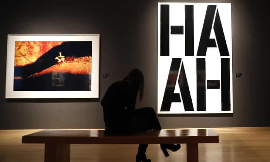 A four-letter Wool work hangs beside a Richard Prince painting at a pre-auction show.