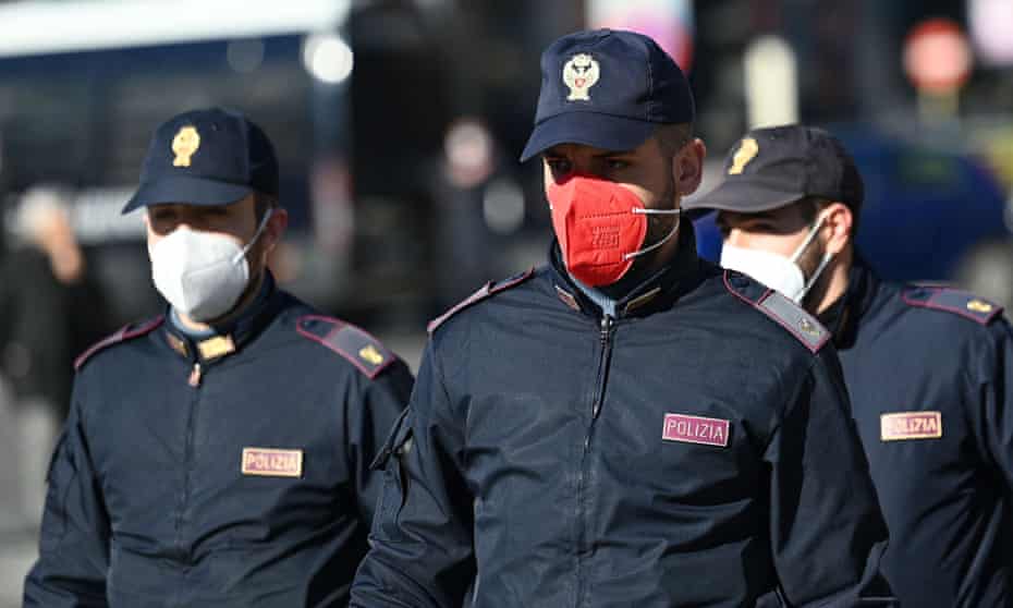 Police officers, one wearing a coloured face mask, on patrol in Rome.