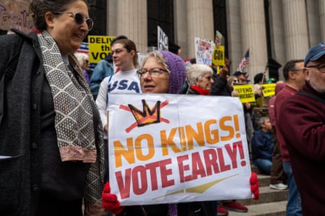A woman holds a 'No Kings! Vote Early!' sign at a rally in New York