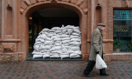 A man walks past sandbags protecting the entrance of a cafe in the Ukrainian city of Dnipro