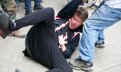 A protester is dragged by others in a Portland street.